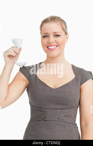 Woman smiling showing a hourglass in her hand Stock Photo