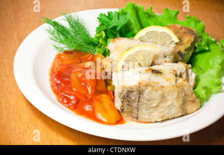 Fried haddock fish with vegetables and greens on white plate Stock Photo