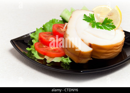 Seafood theme. Smoked calamari with vegetables and greens on black plate, closeup photo Stock Photo