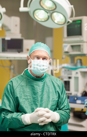 Surgeon smiling while crossing his hands Stock Photo
