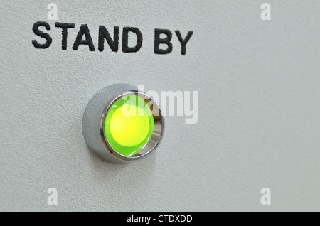 green LED lightning with stand by text over it on the gray panel of the device; focus on green LED Stock Photo
