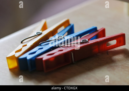 Three colourful pegs. One yellow, one blue and one red. Stock Photo