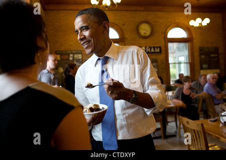 US President Barack Obama eats a hot fudge sundae as he talks with patrons at the UNH Dairy Bar on the University of New Hampshire campus June 25, 2012 in Durham, N.H. Stock Photo