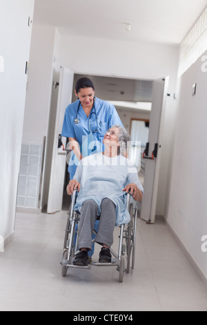 Nurse pushing patient in wheelchair Stock Photo - Alamy
