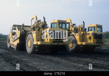 Two Caterpillar-631G Land-Scraper Vehicles stationary upon a land reclamation-site to return wasteland into a open public park. Stock Photo