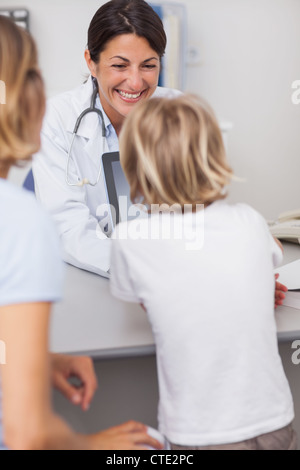 Smiling doctor presenting a tablet computer to a child