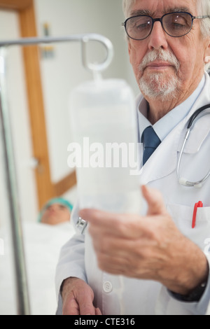Doctor checking an intravenous drip Stock Photo