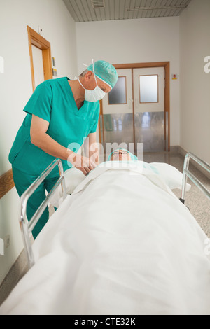 Patient lying on a medical bed next to a surgeon Stock Photo