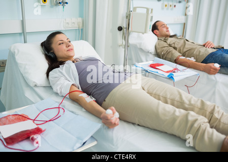 Two transfused patients lying on a bed Stock Photo