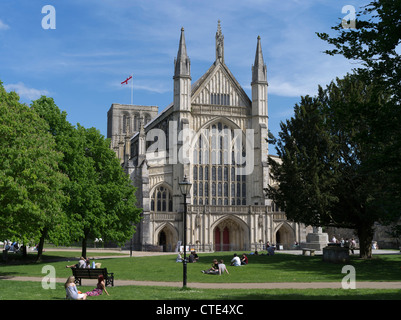 dh Winchester Cathedral WINCHESTER HAMPSHIRE People relaxing on grass front of cathedral west end entrance old minster england uk Stock Photo
