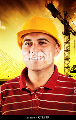 Young construction worker in red shirt wearing yellow hard hat safety equipment. Stock Photo