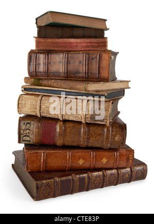 a tall stack of twisting old books varying in shape size and colour on a clean white background Stock Photo