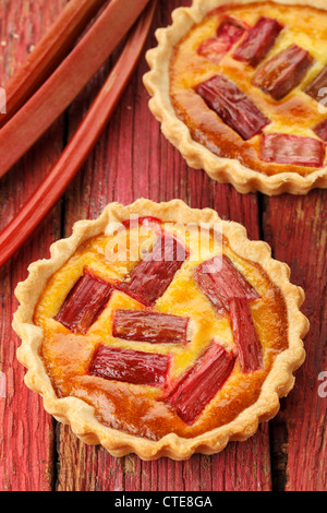 Rhubarb & saffron cream tart on a red wooden background Stock Photo