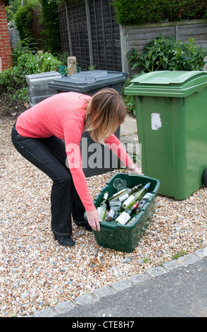 Woman holding a box of glass bottles and jars for recycling Stock Photo