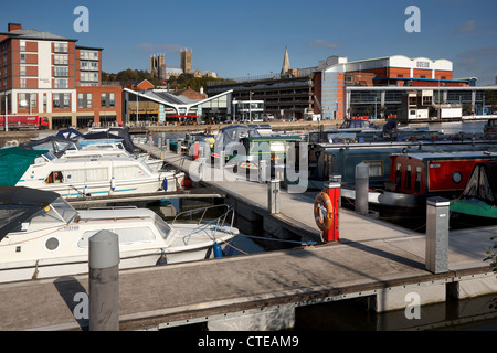 Boats and boardwalks in marina with shops and cathedral beyond at Brayford Waterfront, Lincoln City Centre, Lincolnshire, UK Stock Photo