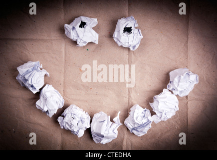 Crumpled up paper balls of white paper make a smiley face Stock Photo