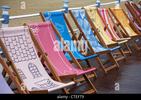 Weymouth Esplanade is decorated with 500 deckchairs, deck chairs,  designed by locals at Weymouth beach, Dorset UK on a wet rainy day in July Stock Photo