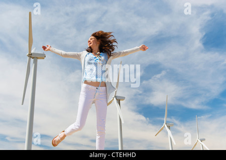 USA, California, Palm Springs, Woman jumping in front of wind turbines Stock Photo