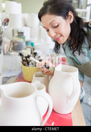 USA, New Jersey, Jersey City, Female artist decorating pottery in studio Stock Photo