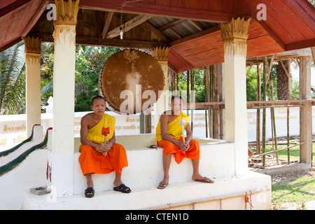 Young novice monks after having call the faithful to prayer (Muang Ngoi Neua - Laos). Jeunes moines novices marquant une pause. Stock Photo