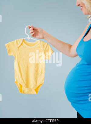 A vertical shot of a young pregnant woman with a pink sleeping dress over a  white background Stock Photo - Alamy