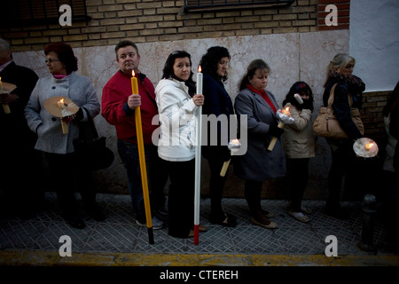 People hold candles during the procession of Our Father Jesus of Humility and Patience during Easter in Puente Genil, Spain Stock Photo