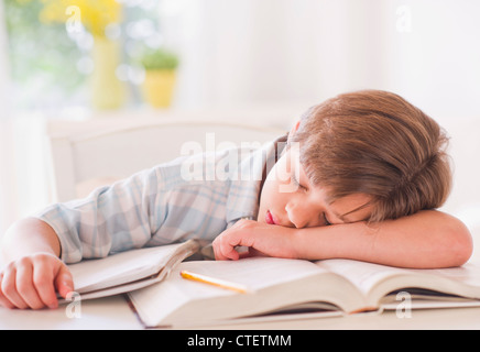 USA, New Jersey, Jersey City, Boy (10-11 years) sleeping on books while doing homework Stock Photo