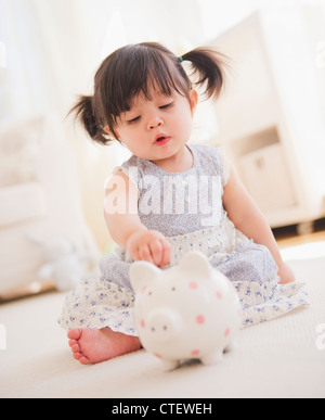 Baby girl playing with a piggy bank Stock Photo - Alamy