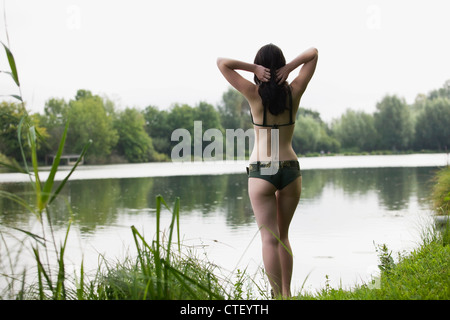 France, Picardie, Albert, Young woman in bikini standing on lake shore Stock Photo