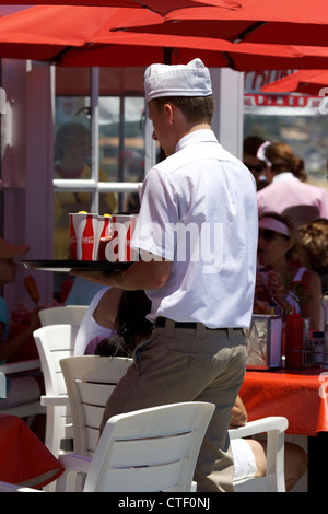 Waiter carrying a tray of drinks at Ruby's restaurant on Balboa pier Newport Beach California Stock Photo