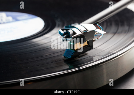 Playing a vinyl record on a record player - LP record on a retro turntable  with tone arm and cartridge Stock Photo