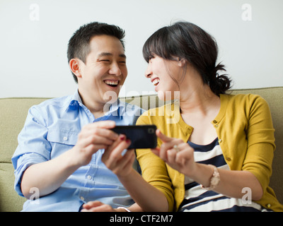 USA, Utah, Salt Lake City, Young happy couple sitting on sofa Stock Photo
