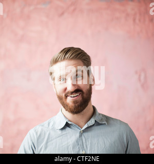 Portrait of laughing young man against pin background Stock Photo