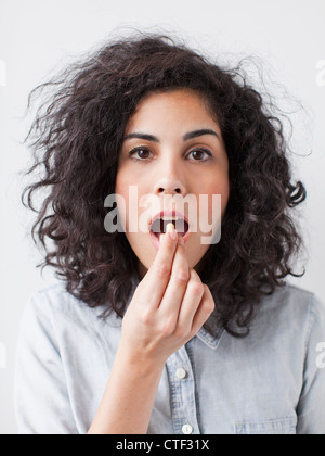 Young woman taking pill Stock Photo