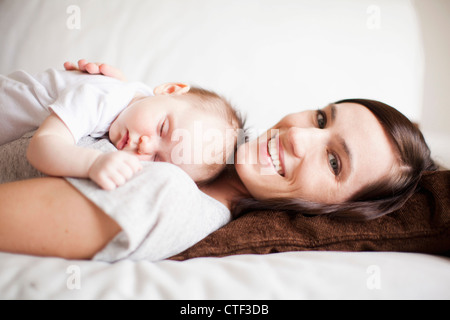Mother embracing sleeping baby girl (2-5 months) Stock Photo