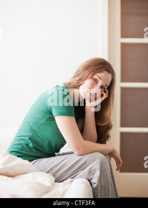 USA, Utah, Salt Lake City, Sad young woman sitting in bed Stock Photo