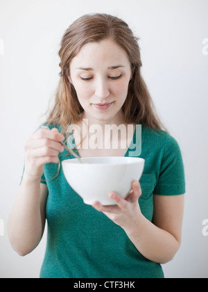 Happy young woman enjoying bowl of cornflakes Stock Photo