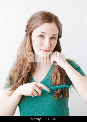 Attractive young woman combing hair Stock Photo