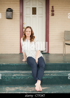 USA, Utah, Salt Lake City, Portrait of happy young woman standing on porch Stock Photo