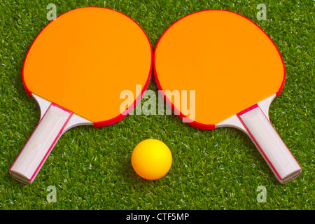Two ping pong rackets with an orange ball Stock Photo