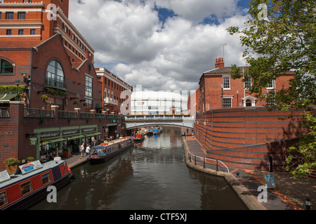 The National Indoor Arena or NIA in Birmingham seen from Brindley Place. Boats moored along the canal. Stock Photo