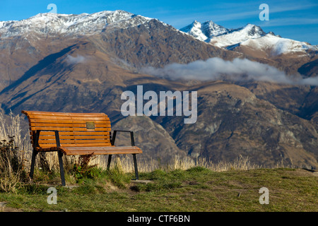 Bench overlooking the Remarkables mountains above Queenstown, New Zealand Stock Photo