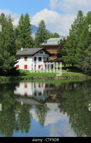 Two small house reflecting in the white lake by summer, Crans Montana, Switzerland Stock Photo
