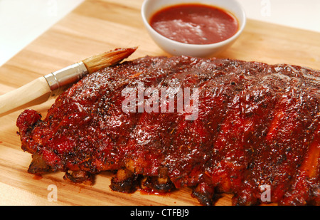 Slab of freshly grilled BBQ spare ribs with dipping sauce Stock Photo