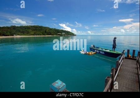 Man in boat at jetty, Iama Island (aka Yam Island), central Torres Strait, Queensland, Australia. No MR or PR Stock Photo