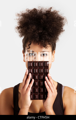 Beautiful African woman holding a huge dark chocolate bar Stock Photo