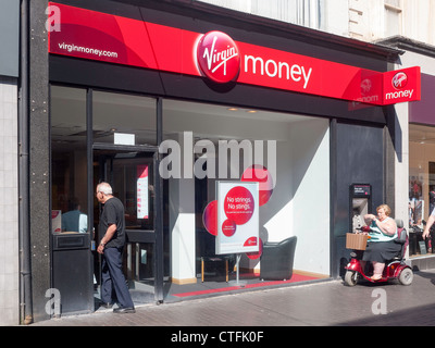 A branch of Virgin Money bank, formerly Northern Rock, in Middlesbrough Cleveland UK with a disabled woman using the cash ATM Stock Photo