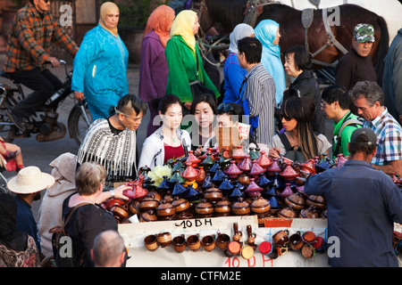 Morocco, Marrakech Square called Djemaa El Fna. Japanese tourists at souvenir stall. Stock Photo