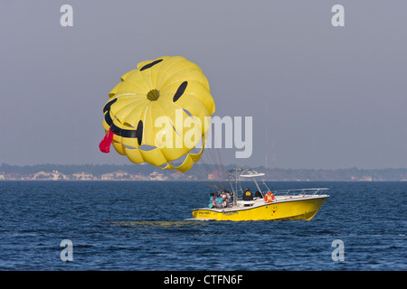 African/American couple getting last minute instructions before beginning their parasailing ride on tow boat at Pensacola Beach, Stock Photo