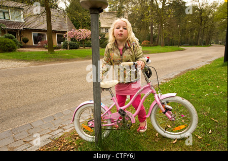 little blond girl parking her pink bike Stock Photo